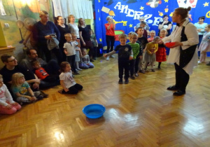 Dzieci wrzucają monety do miski z wodą.